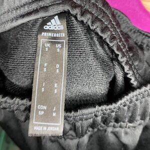Black adidas sweatpants with elastic waistband and drawstring